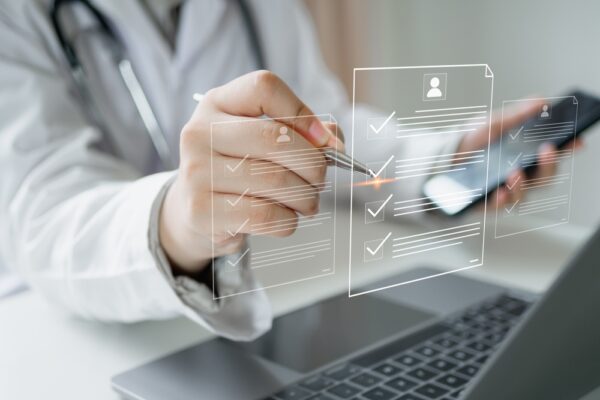 Doctor Uses Laptop To Review Patient Medical Records