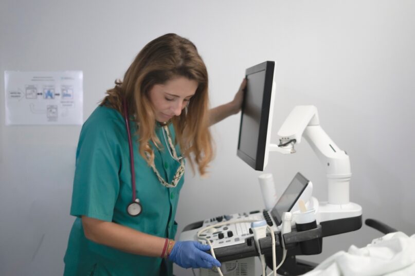 Doctor In Scrubs Preparing An Ultrasound Machine